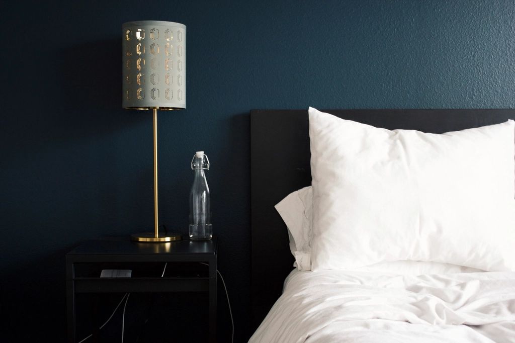 A guest room with a large bed and soft lighting